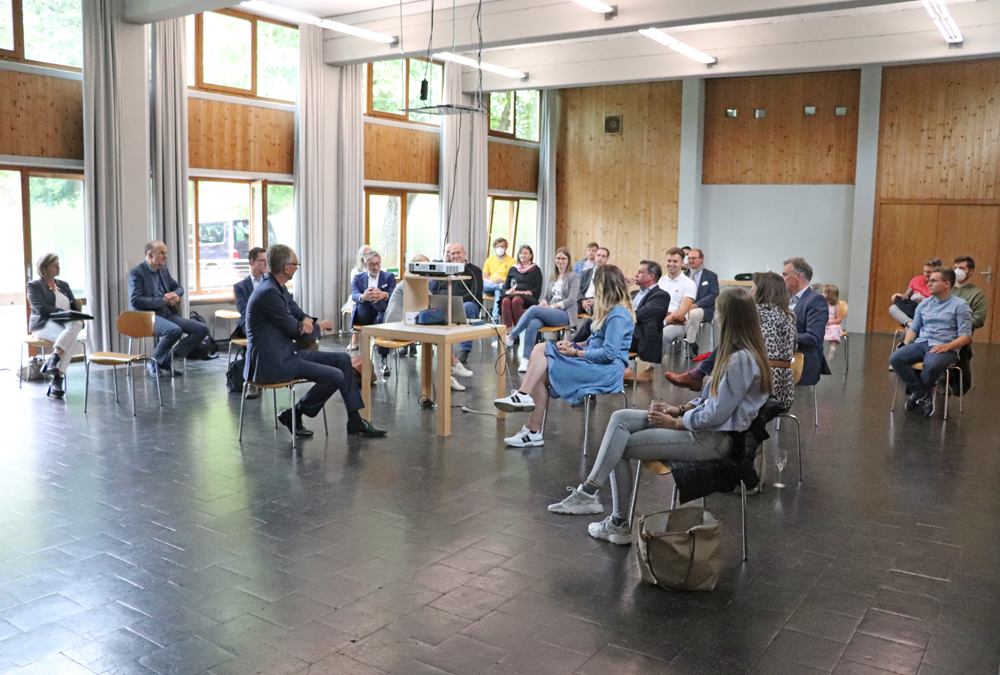 Mentor:innen und Mentees sitzen in der Aula der Hochschule für Gestaltung und unterhalten sich. | Bild: D. Barsch